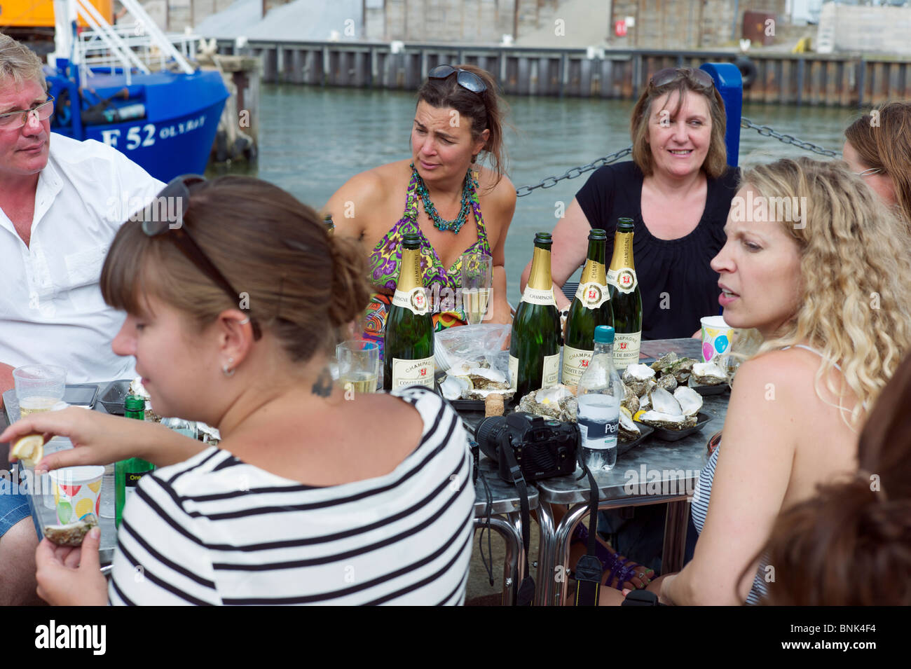 Persone mangiare ostriche e bere champagne a Whitstable Oyster Festival Foto Stock