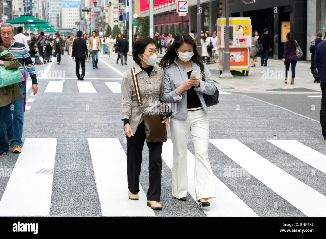 Le donne di protezione da indossare maschere viso in Chuo-dori a Ginza 4-chome, Tokyo, Giappone Foto Stock