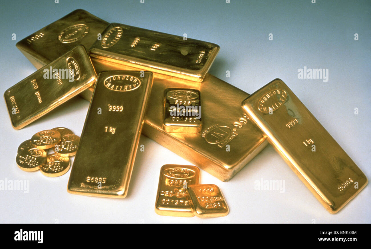 Gold bullion bars e monete su sfondo bianco, London, England, Regno Unito Foto Stock