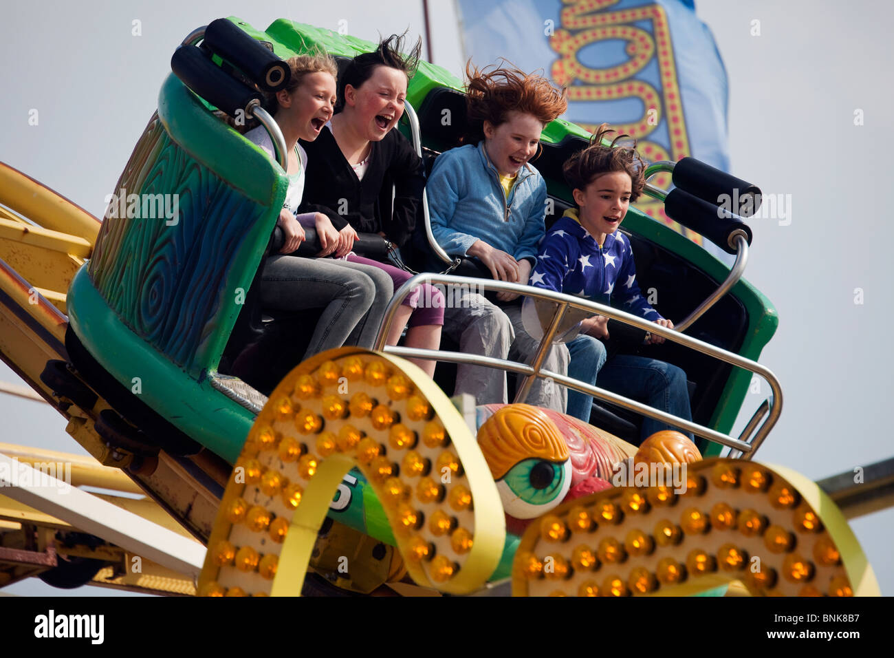 Le quattro ragazze urlando sulle montagne russe al molo di Brighton Inghilterra REGNO UNITO Foto Stock