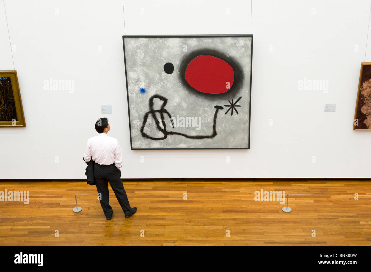 Uomo che guarda all'arte moderna pittura ad olio di Joan Miro nel Museo Nazionale di Arte Occidentale, Tokyo, Giappone Foto Stock