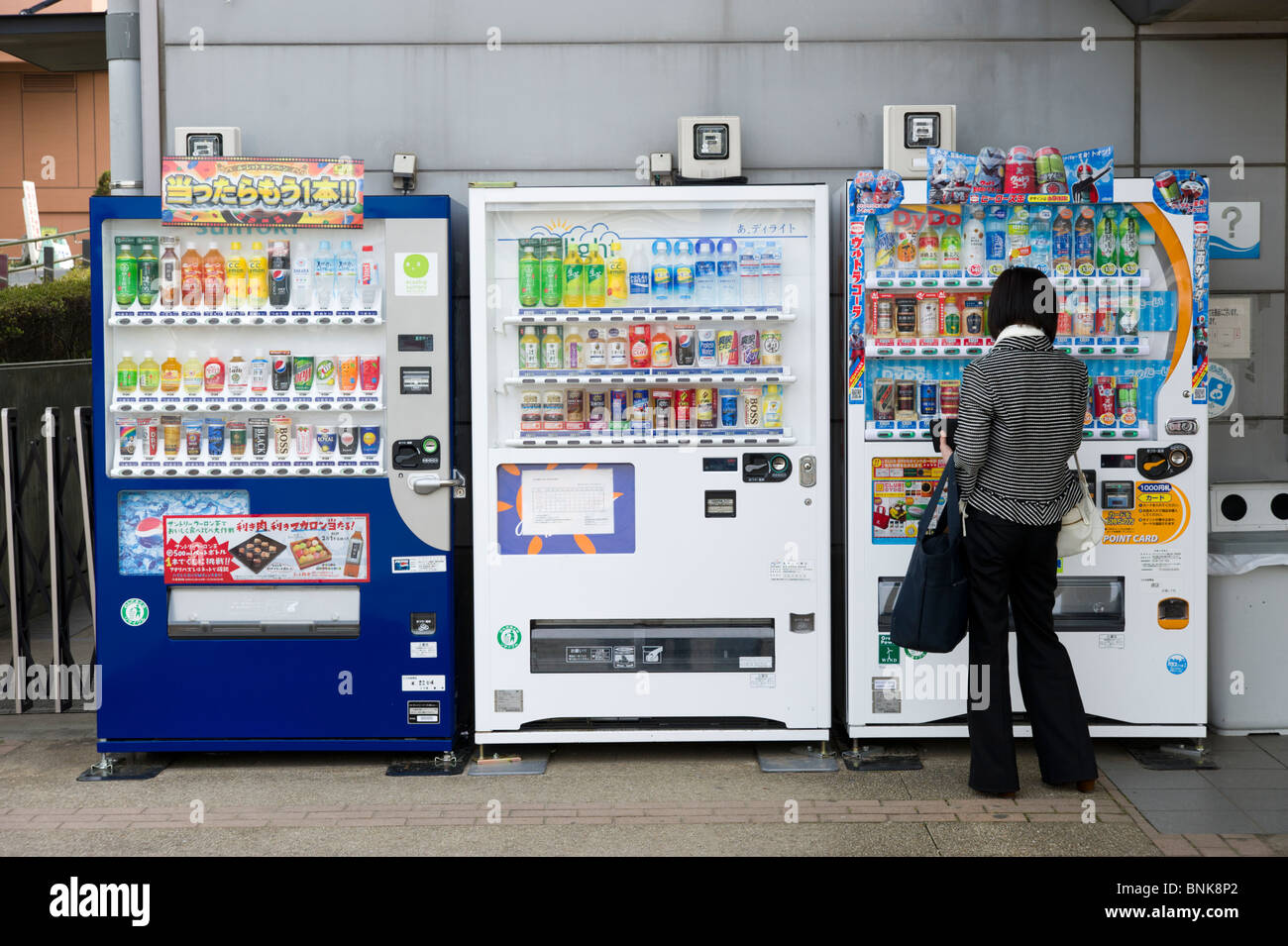 Donna che utilizza un distributore di bevande, Tokyo, Giappone Foto Stock