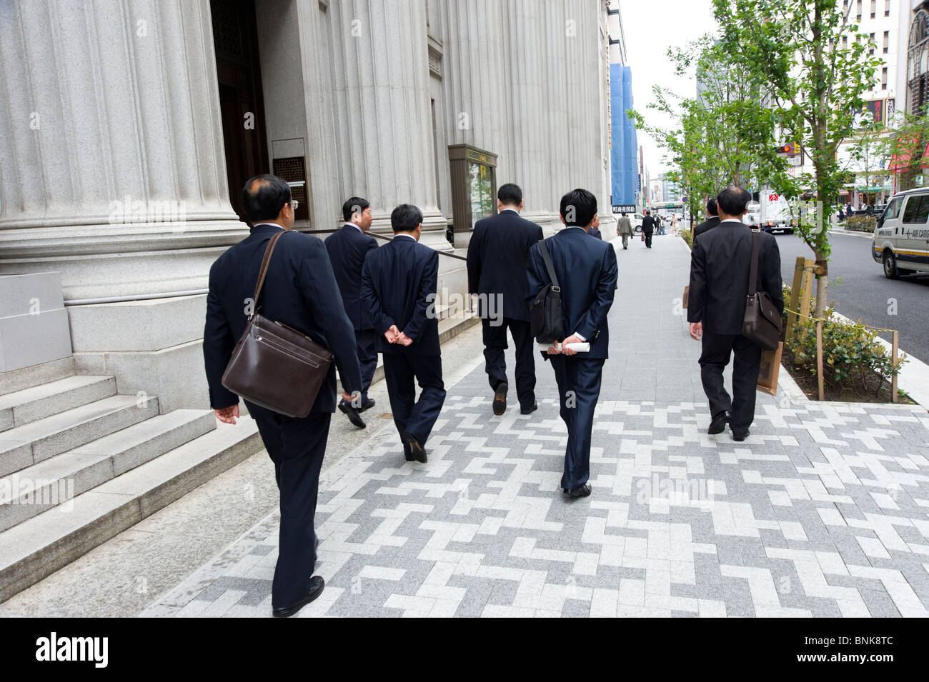 Gruppo di salarymen sulla strada nel Nihombashi financial district, Tokyo, Giappone Foto Stock
