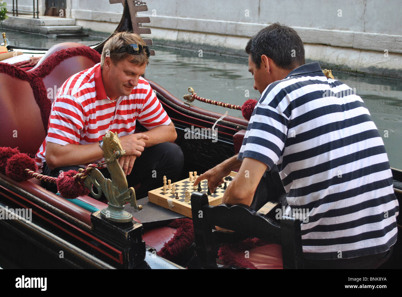 Gondolieri giocare a scacchi in una gondola, Venezia, Italia Foto Stock