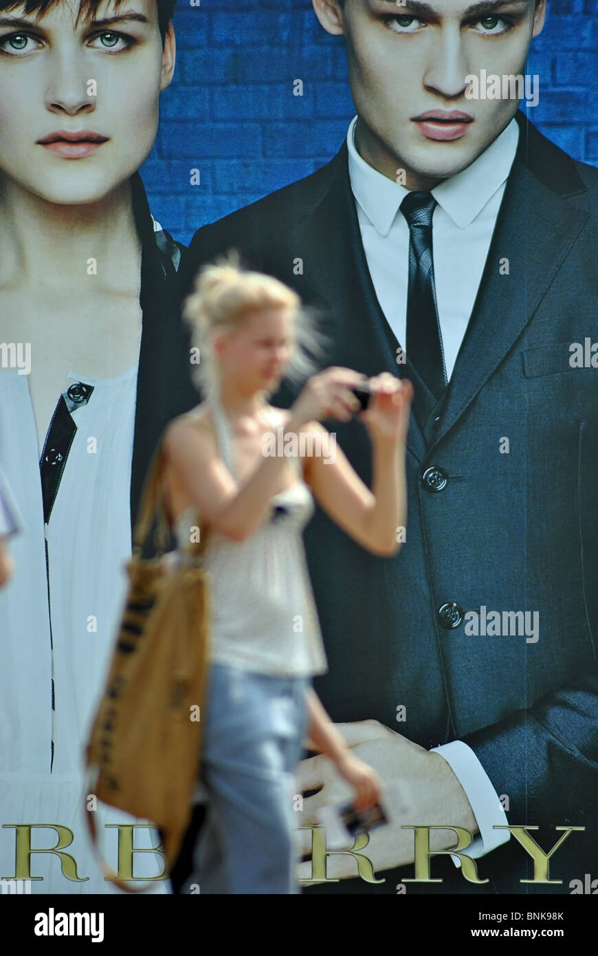 La gente a piedi passato i cartelloni pubblicitari vestiti Burberry, Venezia, Italia Foto Stock