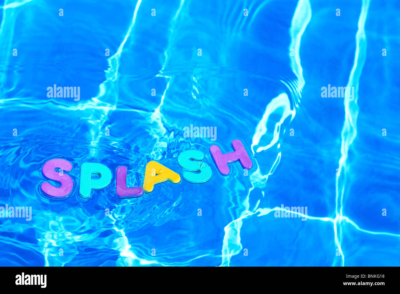 La parola splash di schiuma lettere galleggianti sulla superficie dell'acqua di piscina Foto Stock