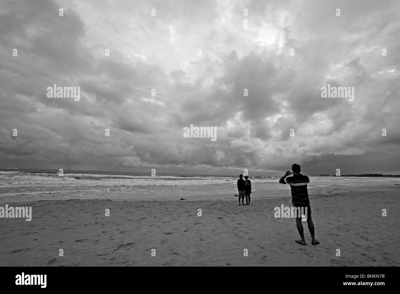 I turisti tenendo snap shots di ogni altro in Bentota beach in Sri Lanka Foto Stock