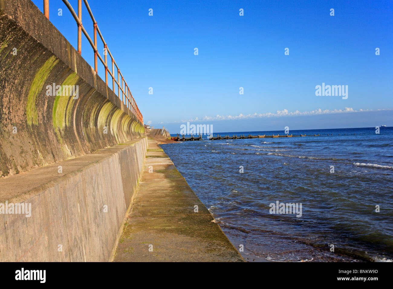 Mare del Nord che lambiscono la parete del mare a Overstrand, Norfolk, Inghilterra, Regno Unito. Foto Stock