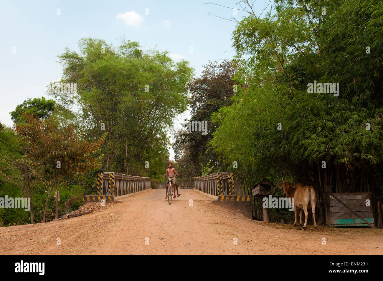 Ragazze cambogiane di una bicicletta su un ponte in campagna - Siem Reap Provincia, Cambogia Foto Stock