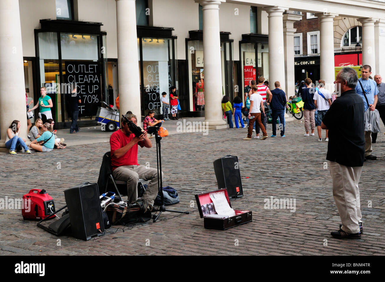 Il cinese musicista di strada Busker giocando un Sheng di strumento a fiato, Covent Garden Piazza di Londra, Inghilterra, Regno Unito Foto Stock