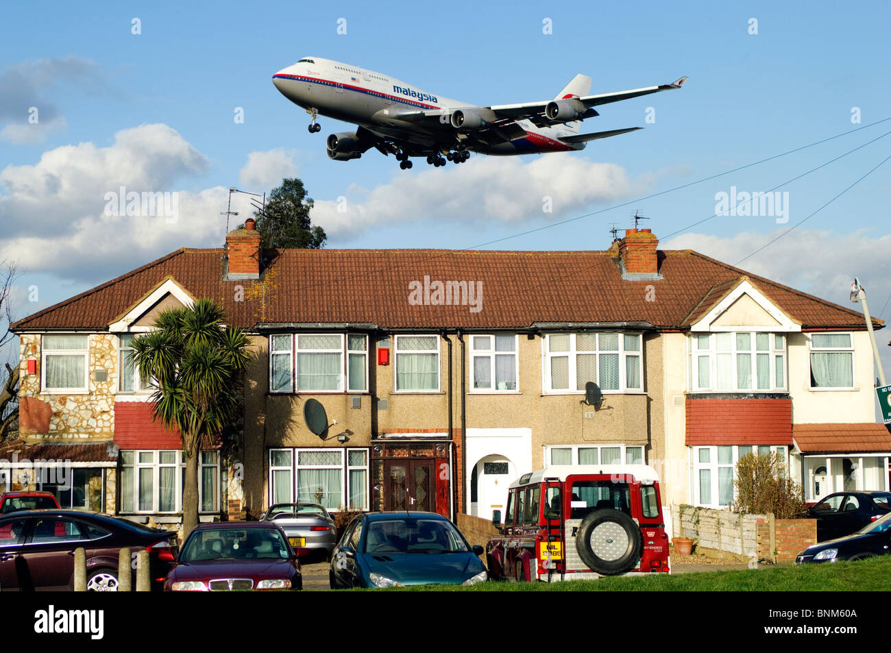 Heathrow pista approccio da parte di Boeing 747, Malaysia Airlines, sull approccio basso sopra le case per l'atterraggio all'Aeroporto di Londra Heathrow, il Mirto Avenue, Regno Unito. Foto Stock