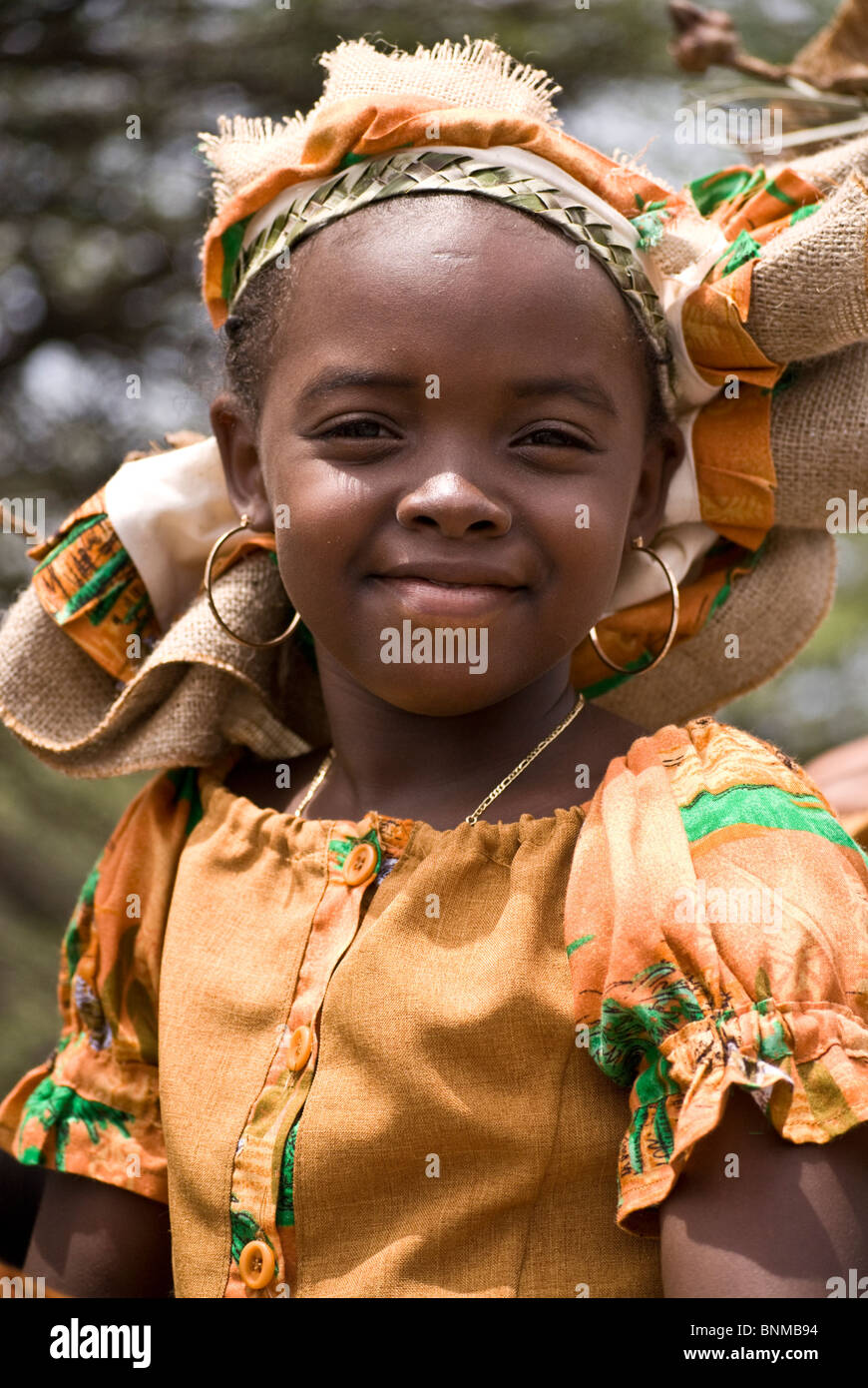 Ragazza giovane indossando il tradizionale colorato costume di Seu e headress all'unica Harvest Festival in Curacao Foto Stock