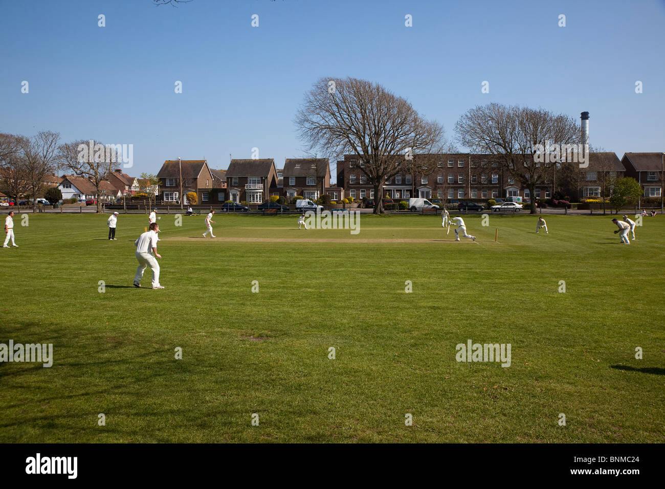 Inghilterra, West Sussex, Southwick, locale squadra di cricket giocando sul verde del villaggio. Foto Stock