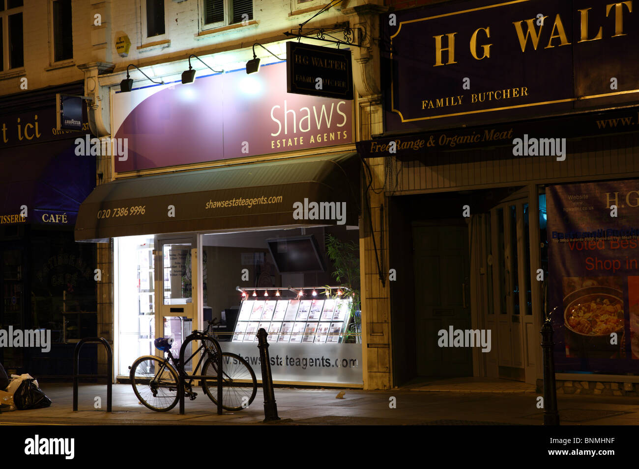 Tempo di notte vista di shop fronti nel West Kensington, London, W14. Foto Stock