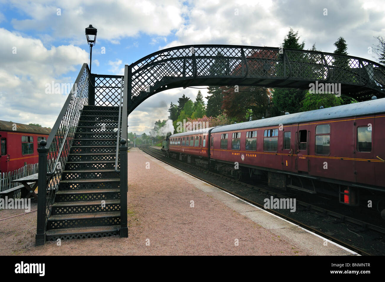 Motore a vapore / locomotore con carrozze rosse al Boat of Garten stazione ferroviaria, Scotland, Regno Unito Foto Stock