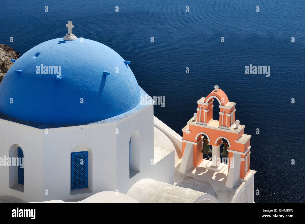 Una chiesa e una torre campanaria alta sopra la caldera di Oia - Santorini Island, Grecia. Foto Stock