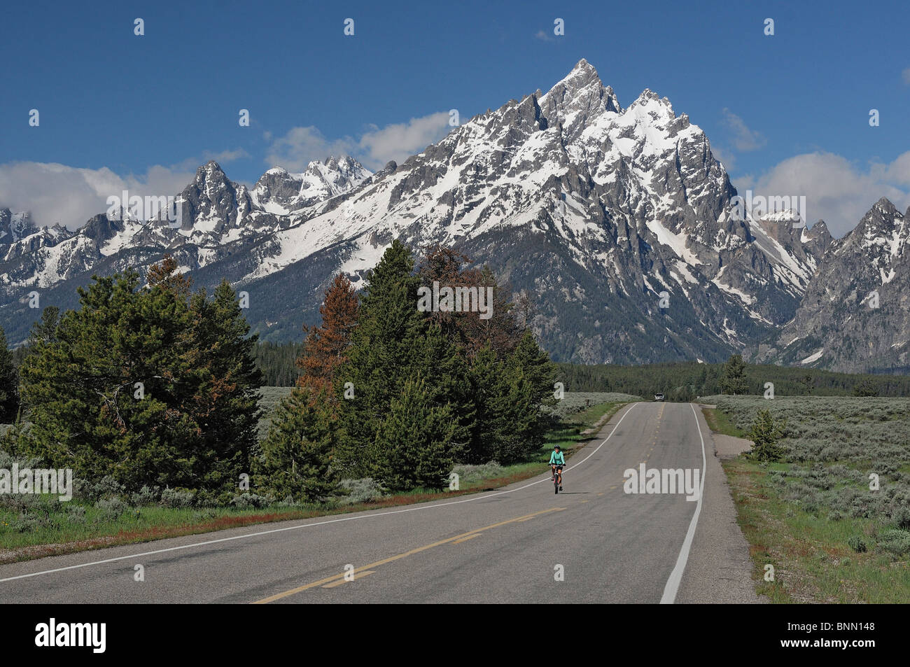 Bicicletta biker rider autostrada Teton Mountain Range Grand Teton National Park Wyoming USA Foto Stock