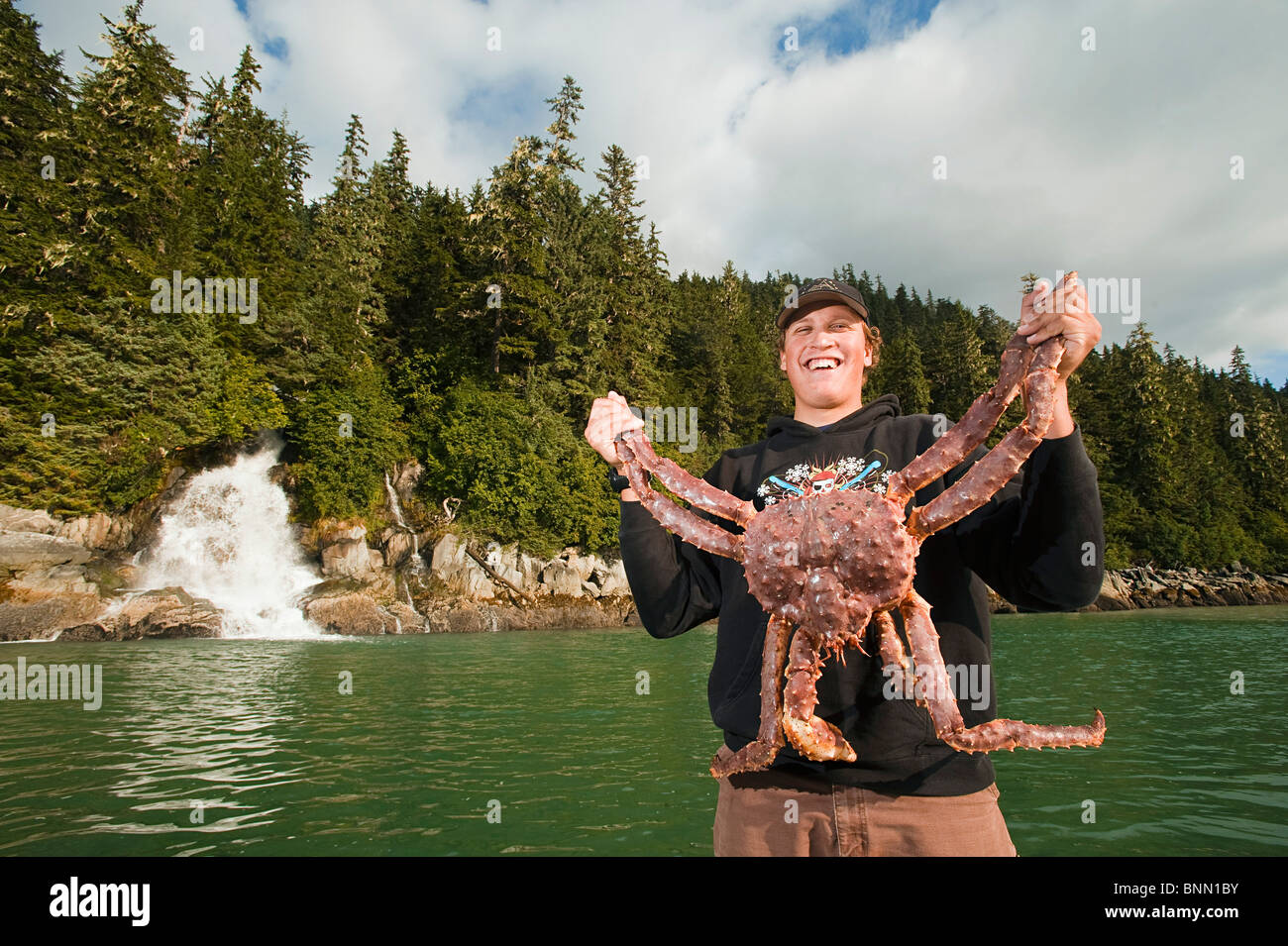 Pescatore può contenere fino a sport catturati re granchio nella Berners Bay con Berners cade in background, Alaska Foto Stock