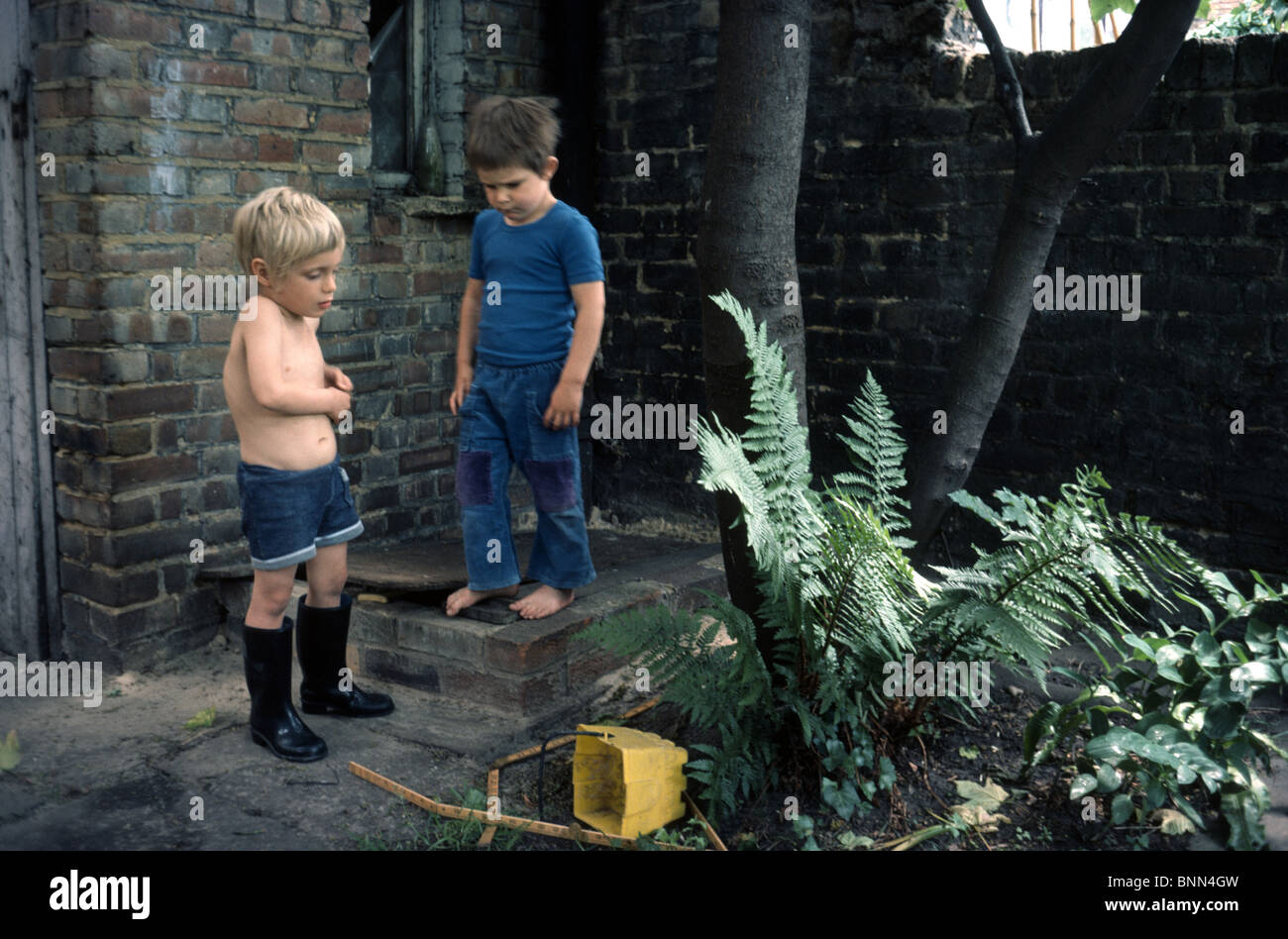Due giovani ragazzi insieme a giocare nel giardino sul retro di una Londra casa a schiera Foto Stock