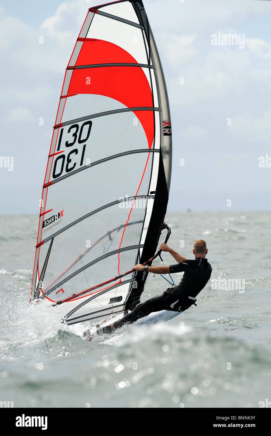 Scheda corso di windsurf racing a Full Tilt nella Baia di Swansea e sito della laguna di marea Foto Stock