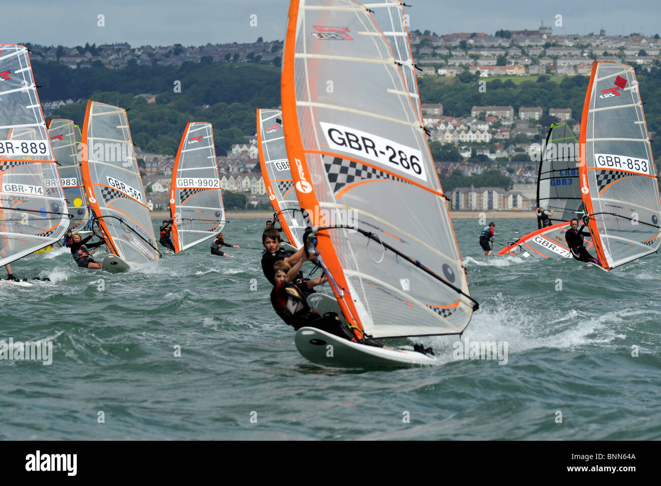 Windsurfers jostle per la posizione di inizio di un corso di gara, Swansea Bay sito della laguna di marea Foto Stock