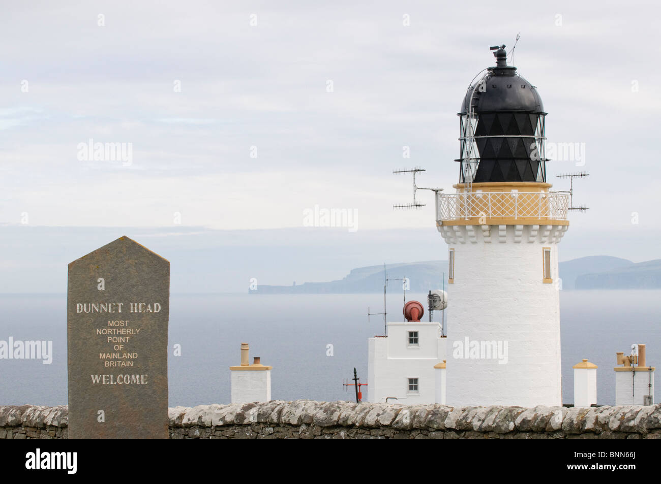 Il faro di Dunnett Testa, Scozia, con Orkney in distanza. La più settentrionale luogo sul continente BRITANNICO. Foto Stock
