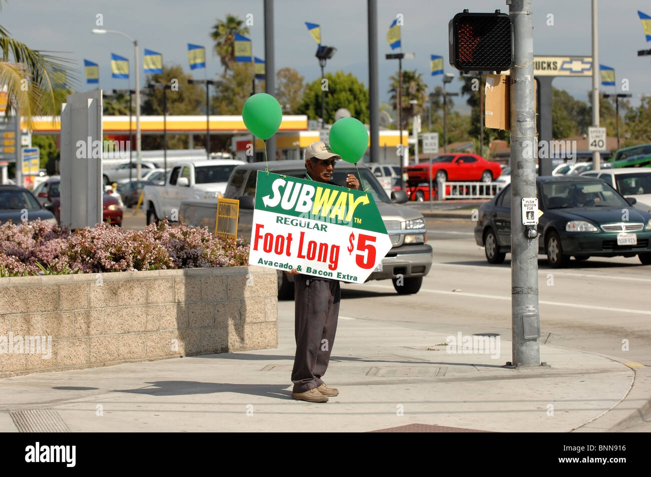 Billboard umano- un uomo detiene un segno pubblicità sull'angolo di Chapman Avenue e Tustin nella città di Orange, CA. Foto Stock