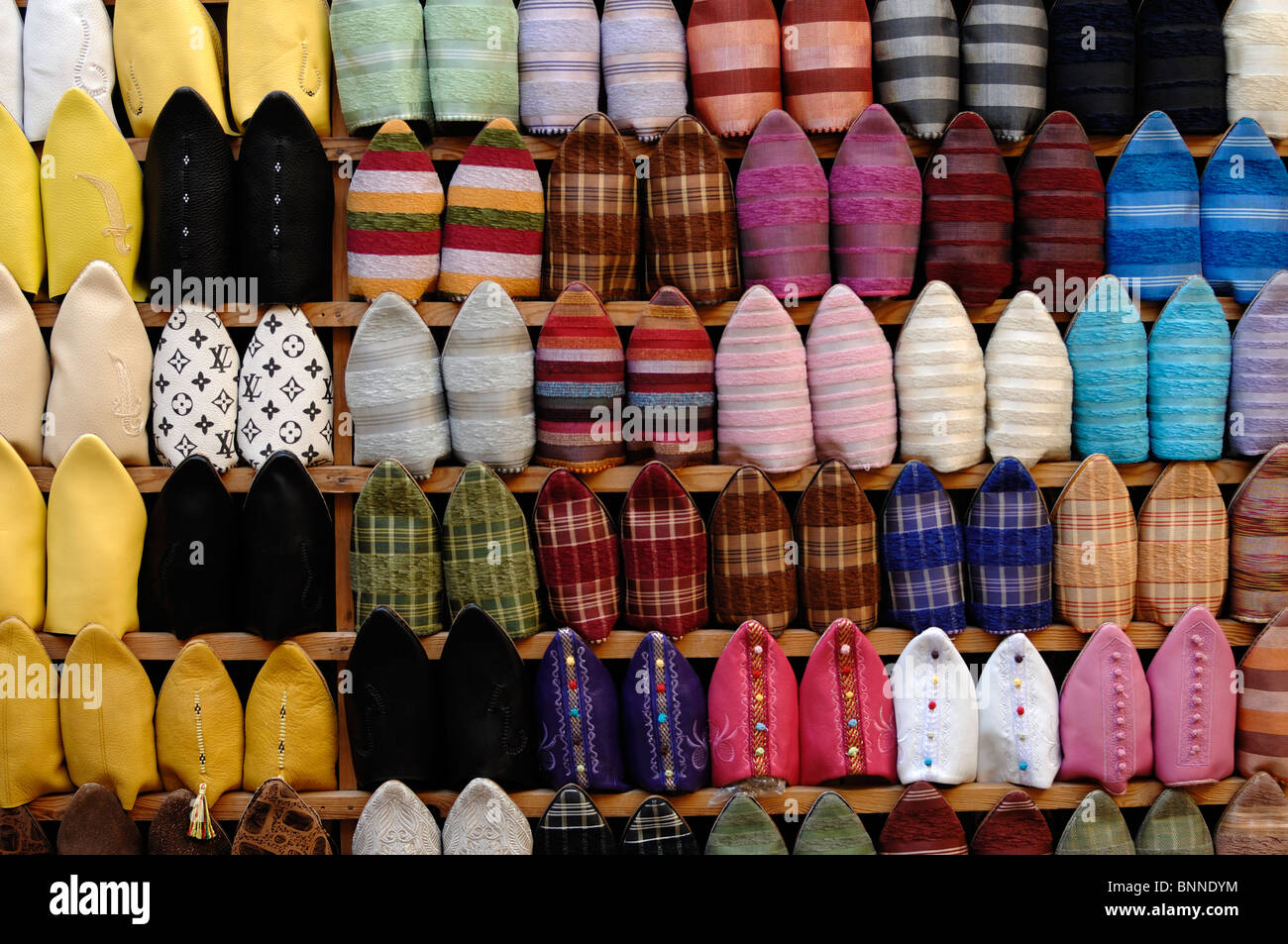 Modello colorato o visualizzazione di pantofole marocchine o Babouches sulla Market Stall nella Medina, o la città vecchia, Fez, Marocco Foto Stock