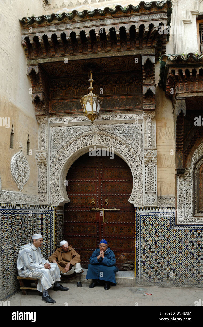 Uomini marocchini in Jellaba tradizionale, cappelli di cranio o costume etnico fuori dalla porta per Sidi Ahmed Tijani Zawiya Moschea, Medina, Fez, Morooco Foto Stock