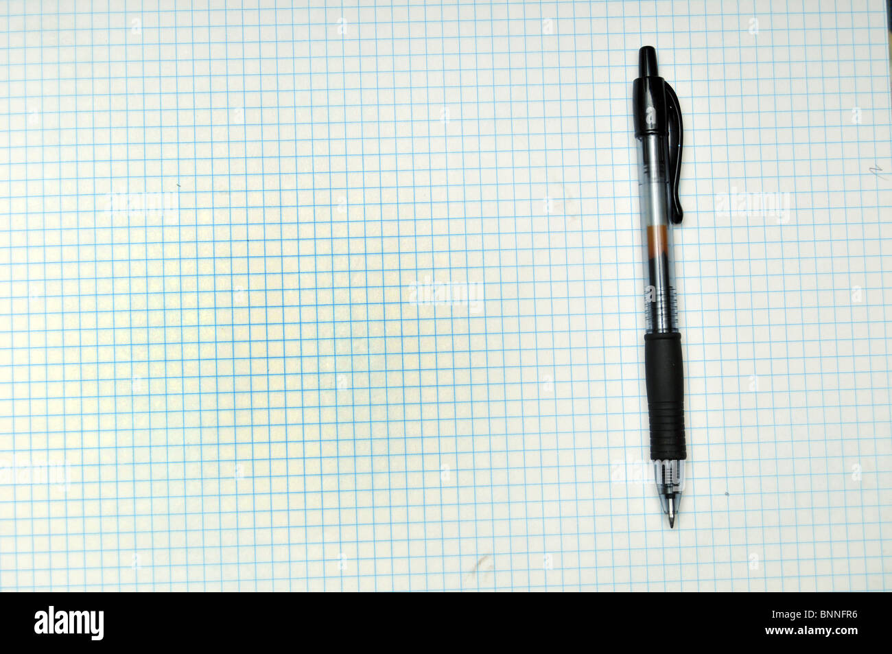 Griglia vuota carta con penna appoggiata sulla parte superiore. Copia spazio sulla sinistra Foto Stock