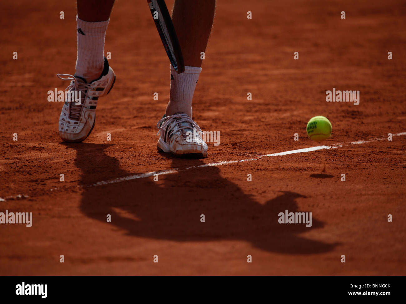 Ombra di un maschio di giocatore di tennis su terra rossa corte di Roland Garros di Parigi Foto Stock