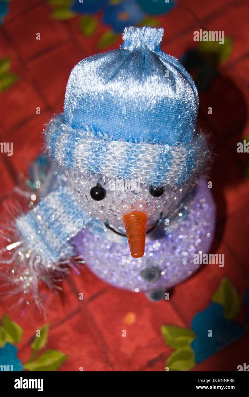 Pupazzo di neve decorazione di Natale ornamento vestito in cappellino e sciarpa con carota grande per il suo naso Foto Stock