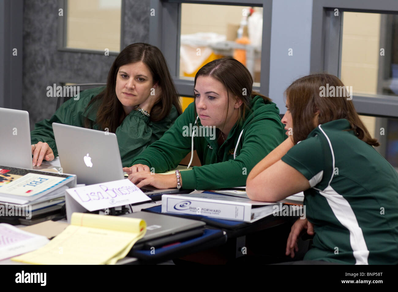 Alta femmina gli insegnanti della scuola di utilizzare i computer laptop per collaborare su piani di lezioni nel corso di formazione in servizio workshop . Foto Stock