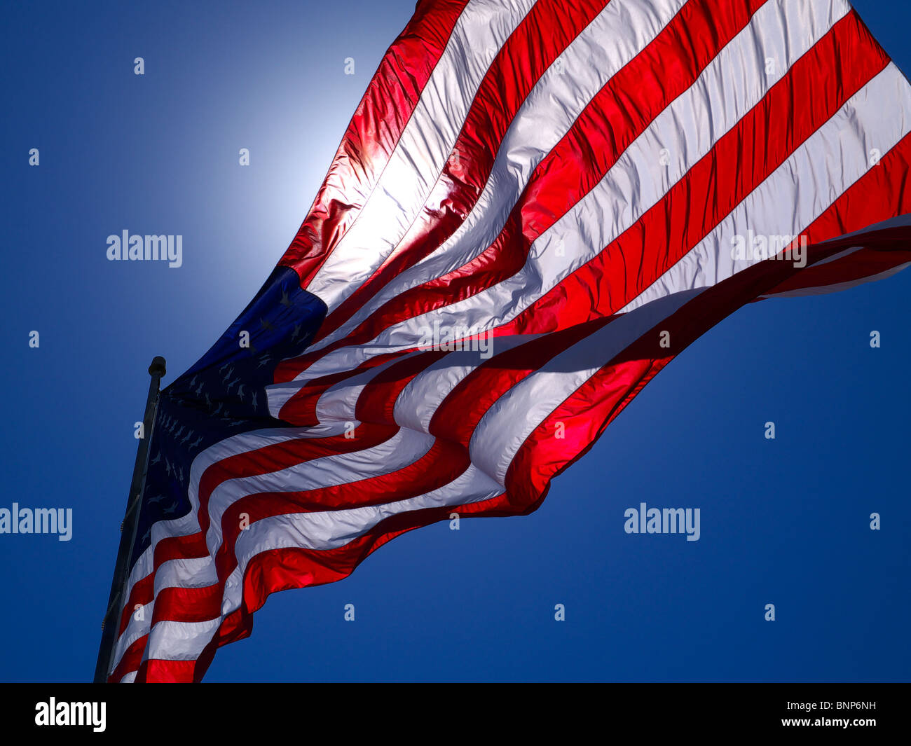 Bandiera degli Stati Uniti con il sole che splende attraverso. Questo grande (20x38 piedi) flag è la pietra angolare della 'Avenue di flag' di Brooklyn, Iowa Foto Stock