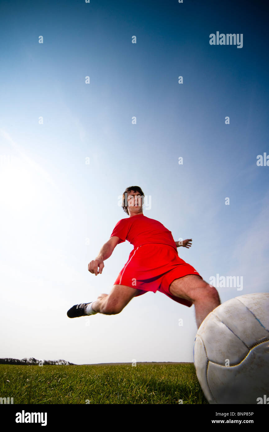 Giocatore di calcio calci palla Foto Stock