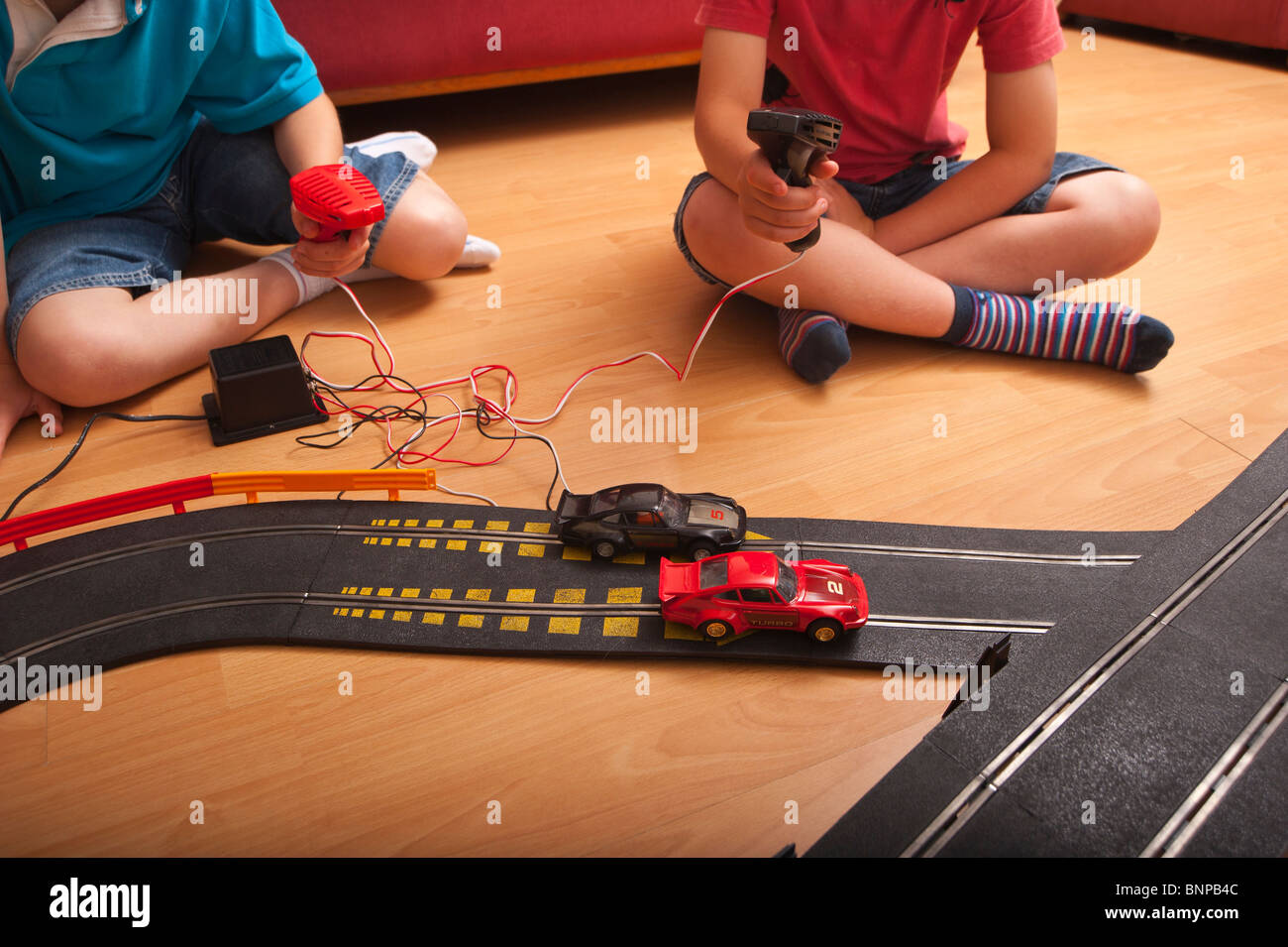 Un modello rilasciato foto di due ragazzi ( 6 & 10 ) suonando con un Hornby Scalextric racing car set game del Regno Unito Foto Stock