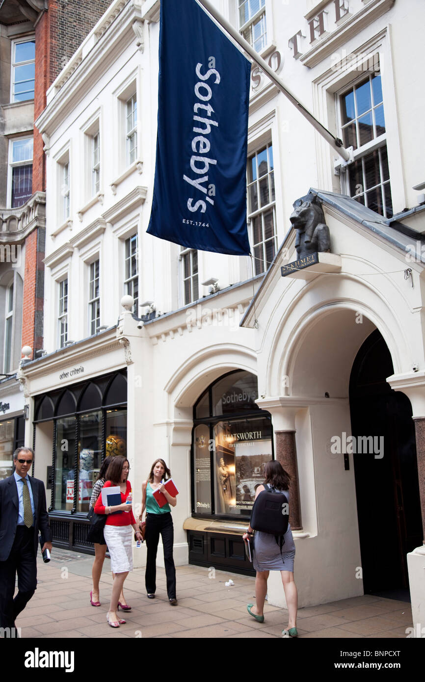 Gli amanti dello shopping pass high end negozi di Londra è Bond Street. Conosciuto per i suoi esclusivi negozi di moda. Sotheby's casa d'aste. Foto Stock