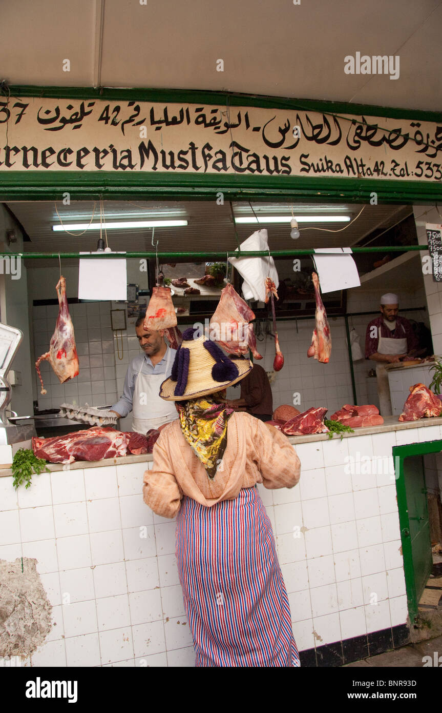 Il Marocco, Tetouan. Storica Medina bazaar. Allevatore locale nel tradizionale hat al mercato macelleria. Foto Stock