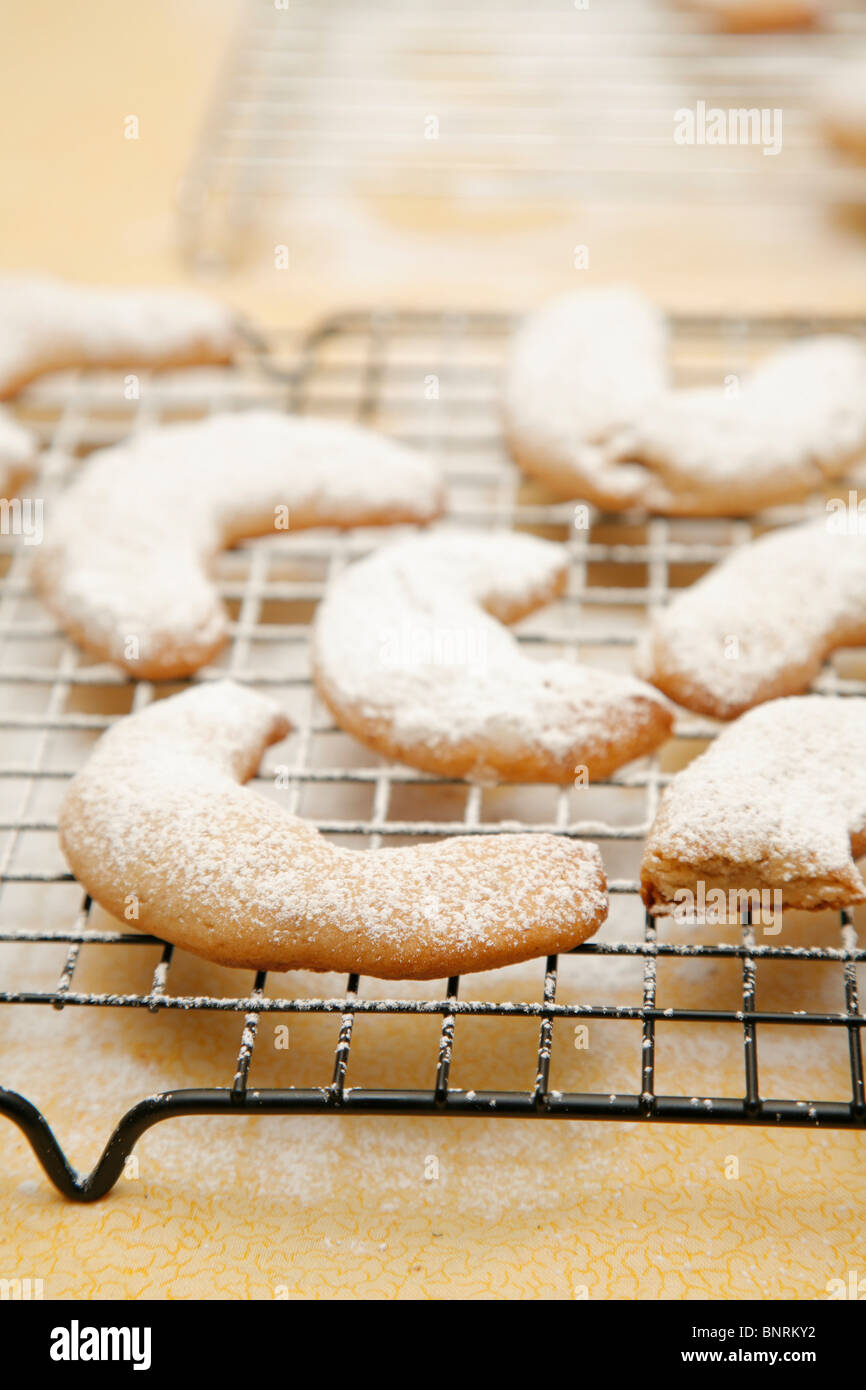 Crescent cookies raffreddare su una griglia da forno spolverati con zucchero a velo Foto Stock