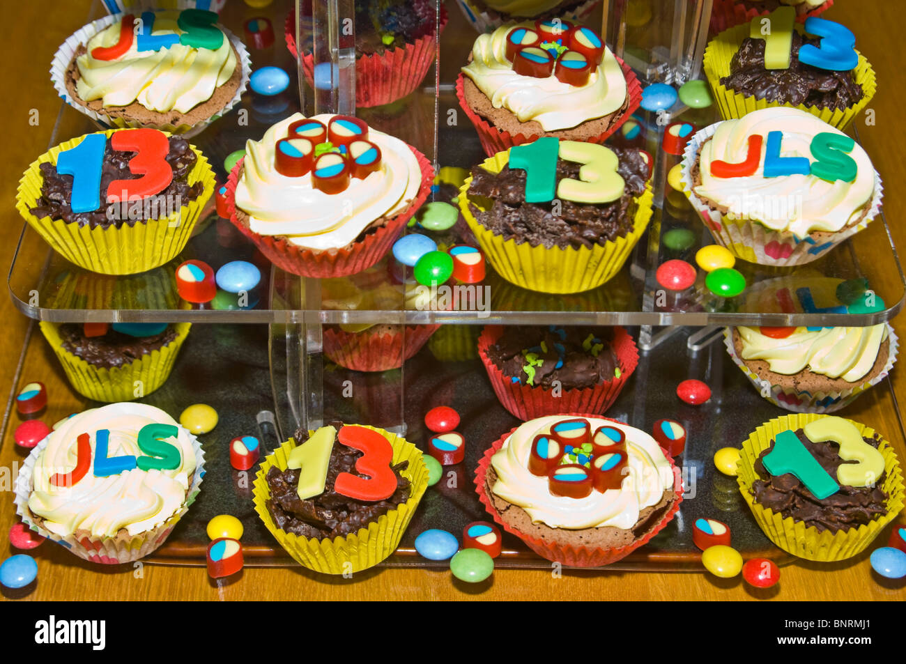 Chiudere orizzontale delle partite di fatto in casa e tazza decorata torte visualizzata per un bambino il compleanno Foto Stock