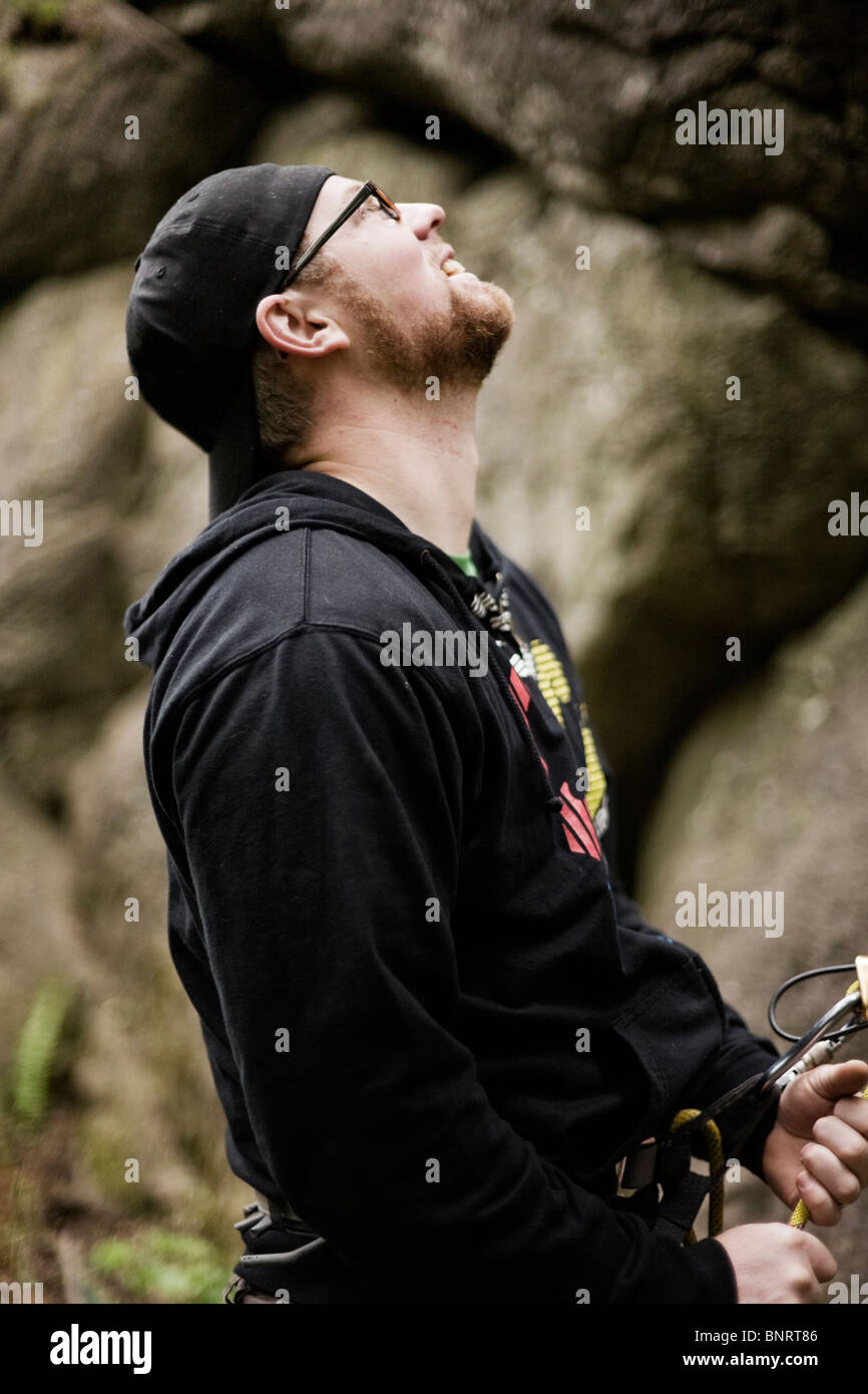 Un ritratto di un uomo sorridente mentre belaying un altro scalatore. Foto Stock