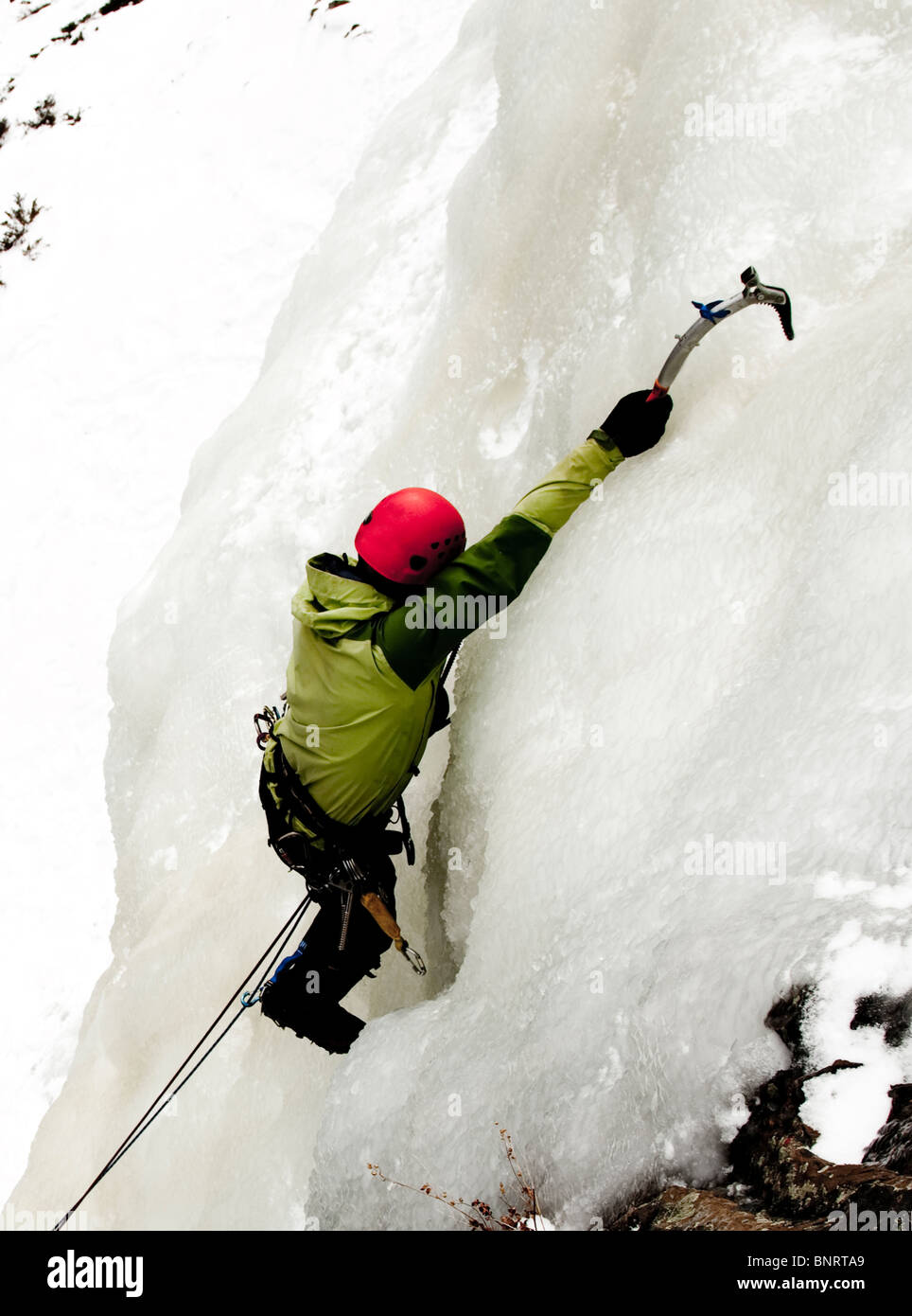 Un uomo di arrampicata su ghiaccio. Foto Stock