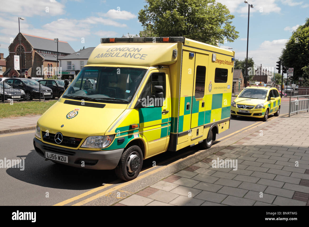 Due Londra servizio ambulanza veicoli parcheggiati sulle doppie linee gialle sulla scena di un incidente a Hounslow, Middx, Regno Unito. Foto Stock