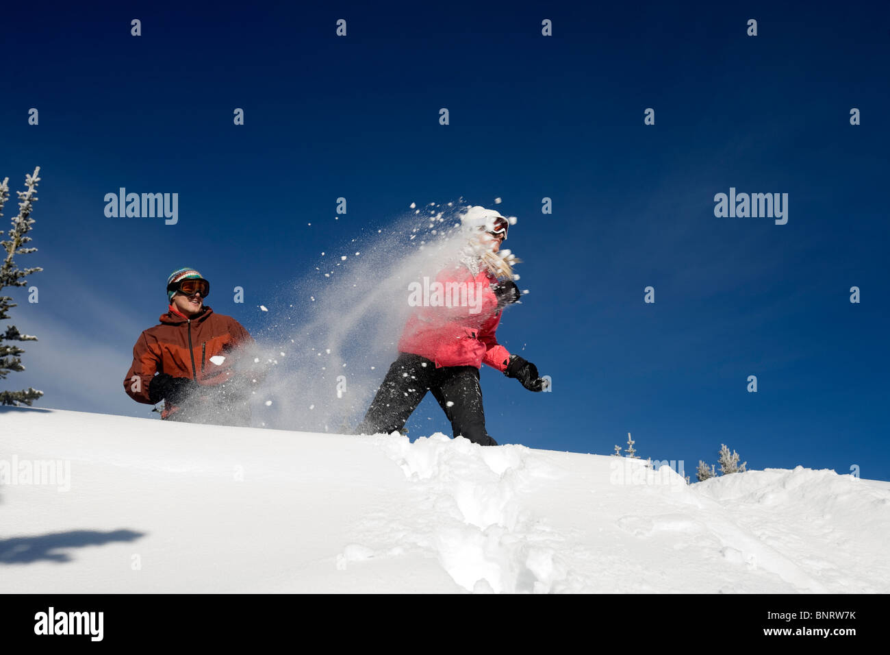 Un uomo e una donna giocare nella neve in montagna. Foto Stock