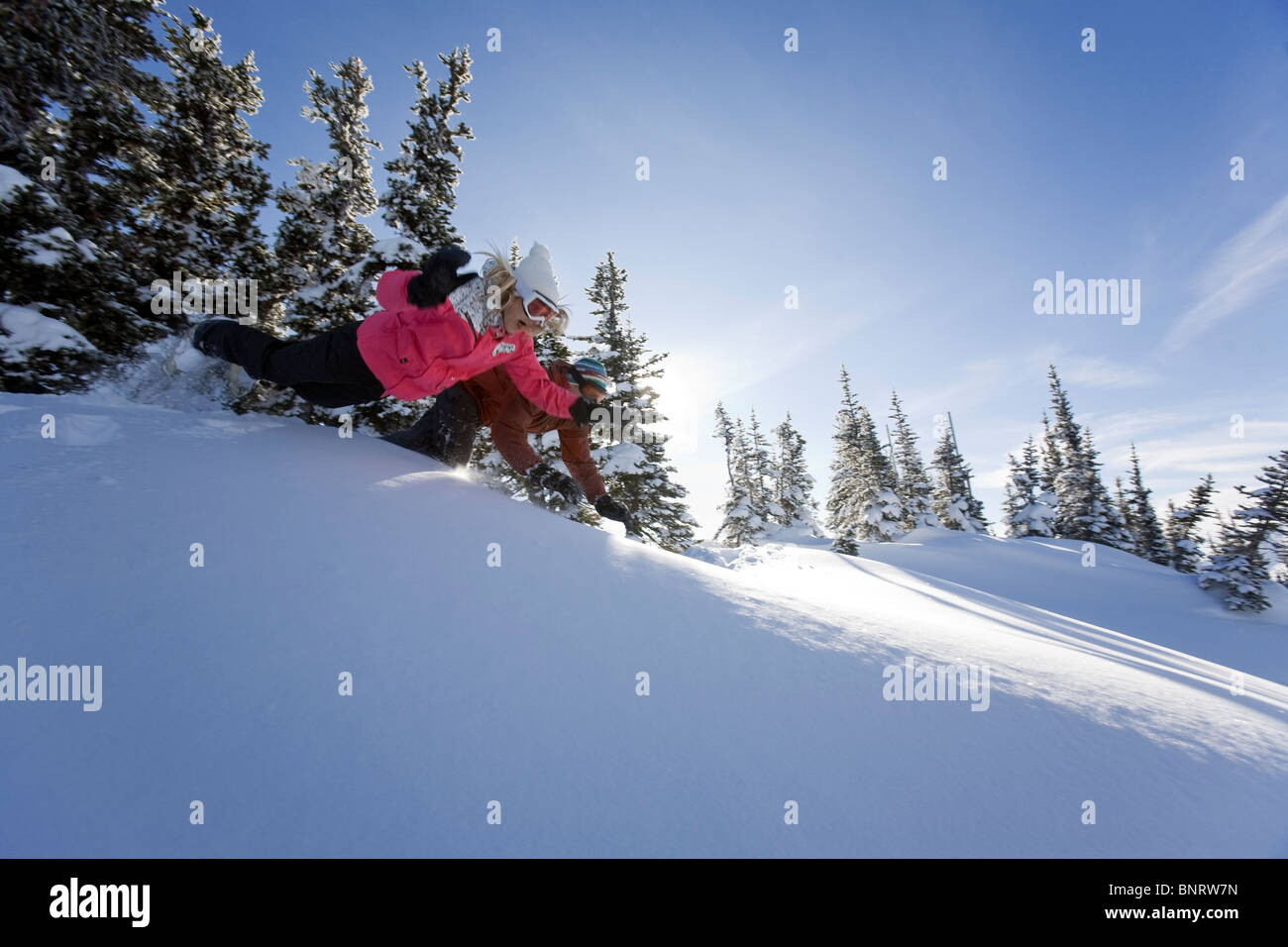 Un uomo e una donna giocare nella neve in montagna. Foto Stock
