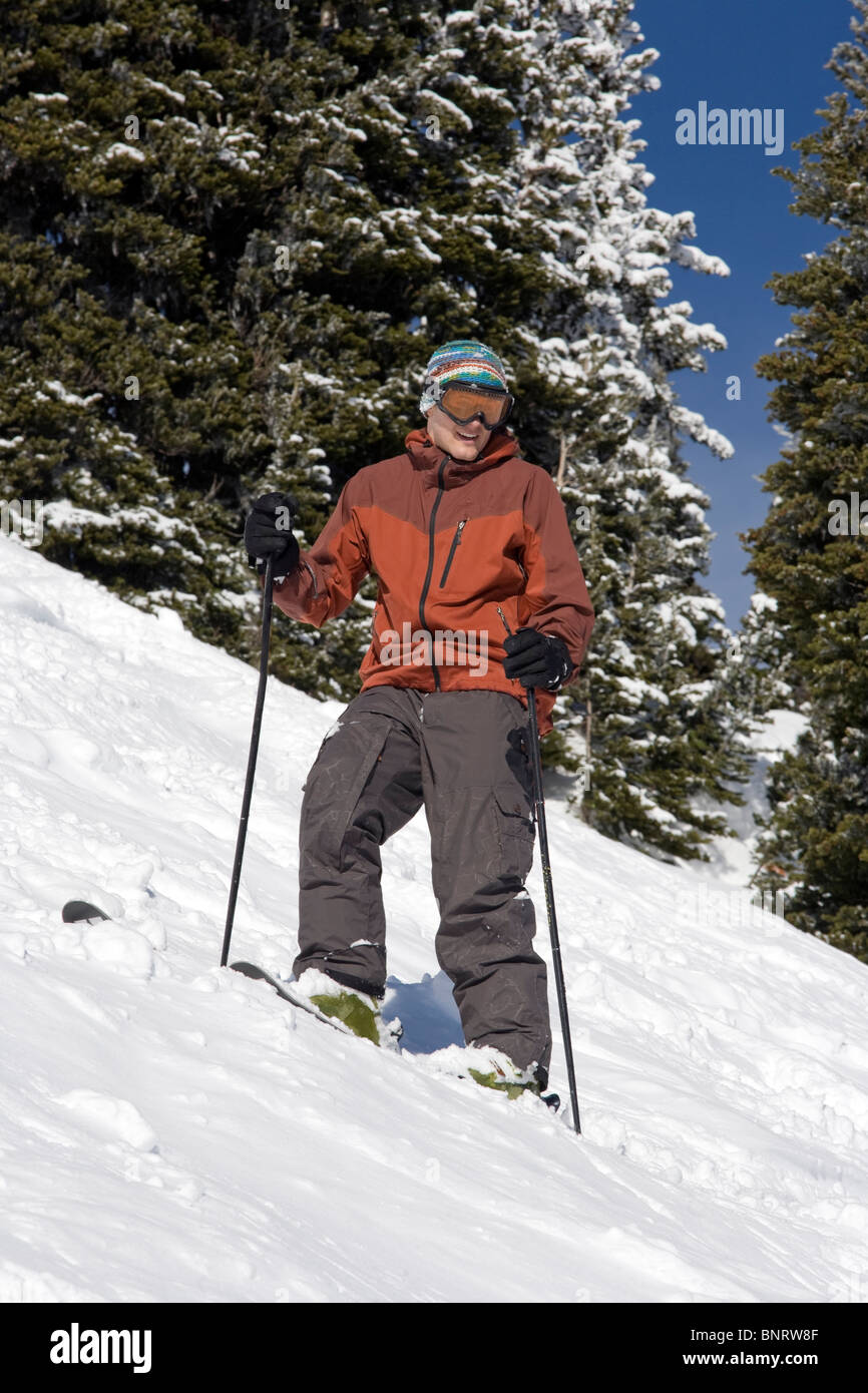 Un uomo sugli sci sorge su un pendio rilevamenti topografici il suo percorso. Foto Stock