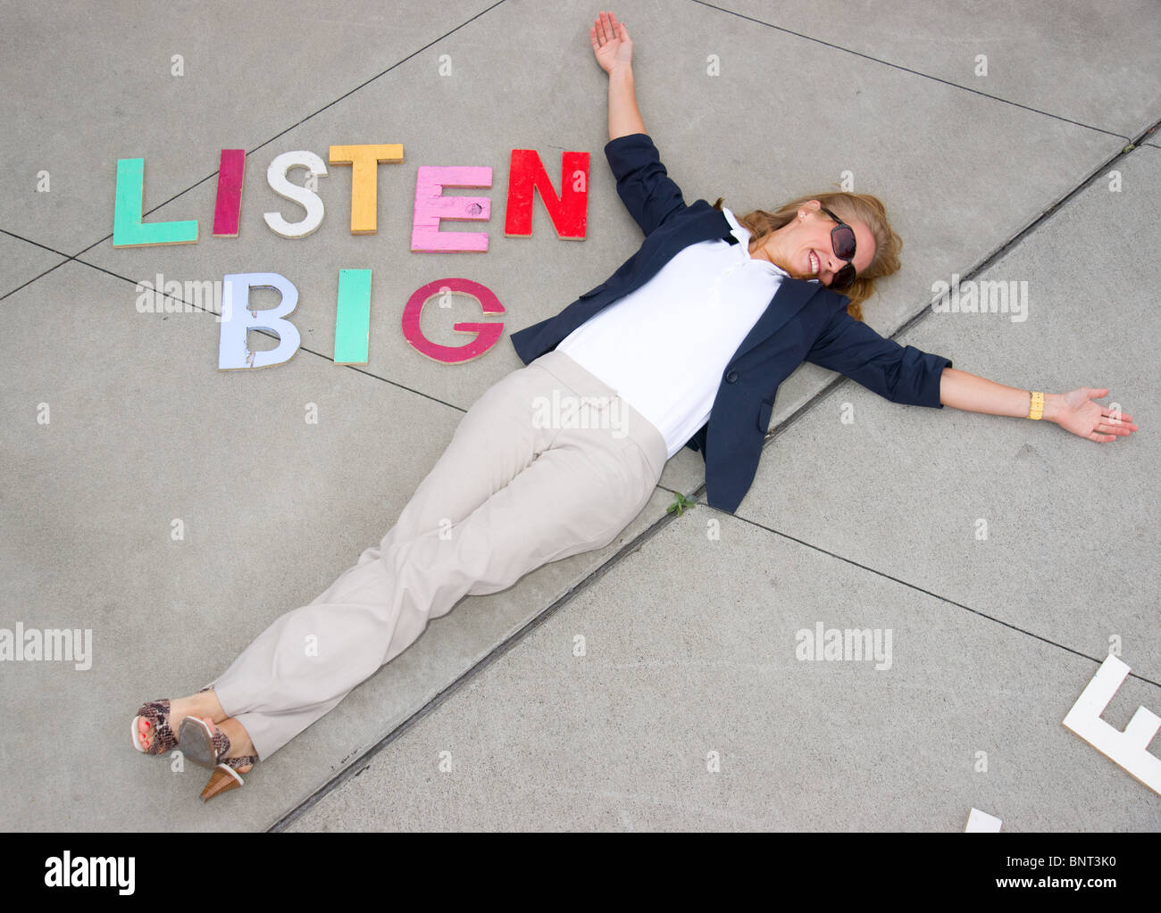 Attraente donna bionda precisa ascoltare con grandi blocchi di ABC Foto Stock