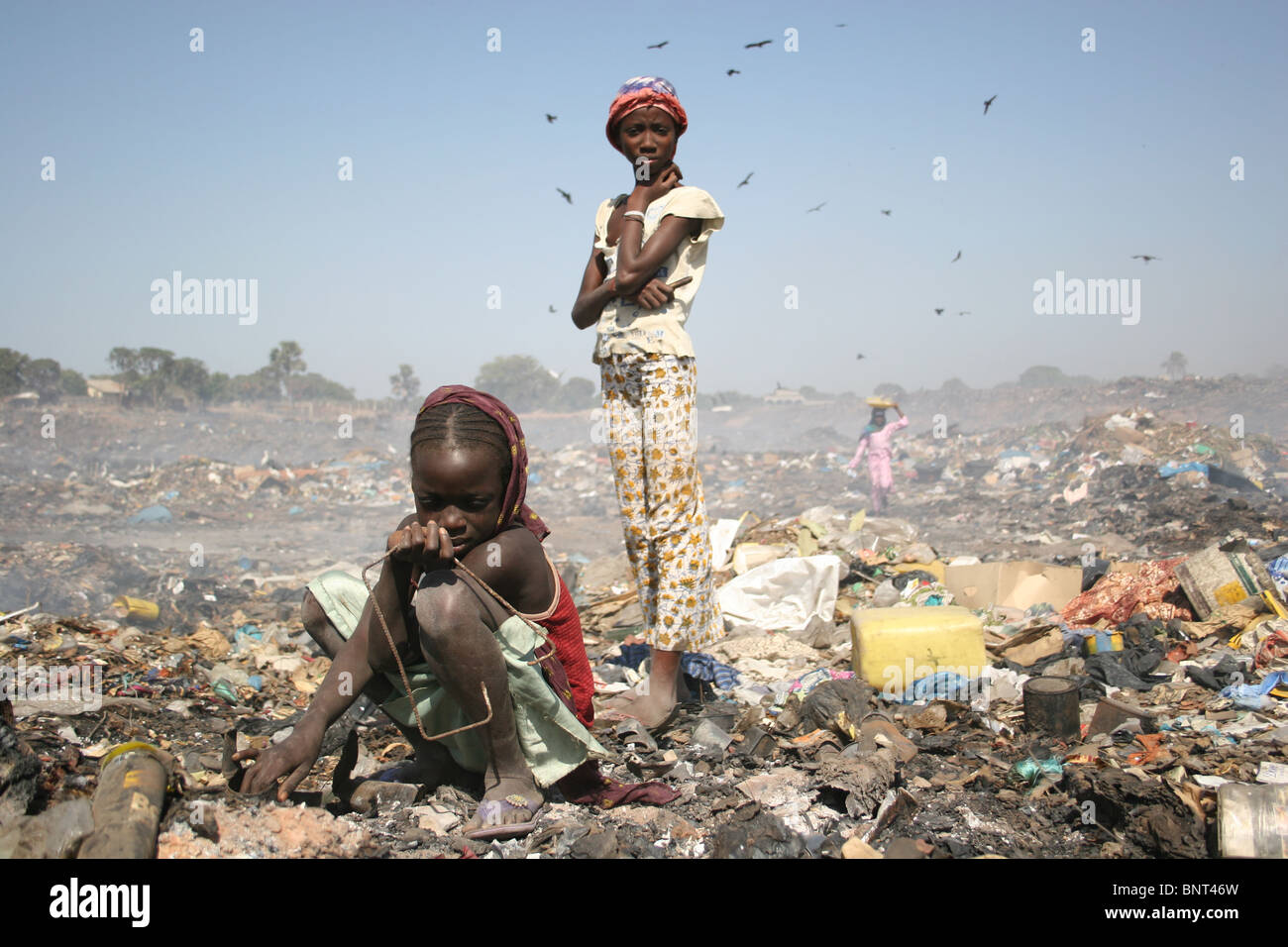 Le ragazze del Gambia alla ricerca di rottami di metallo in Mannjai Kunda discarica, il Gambia. Foto Stock