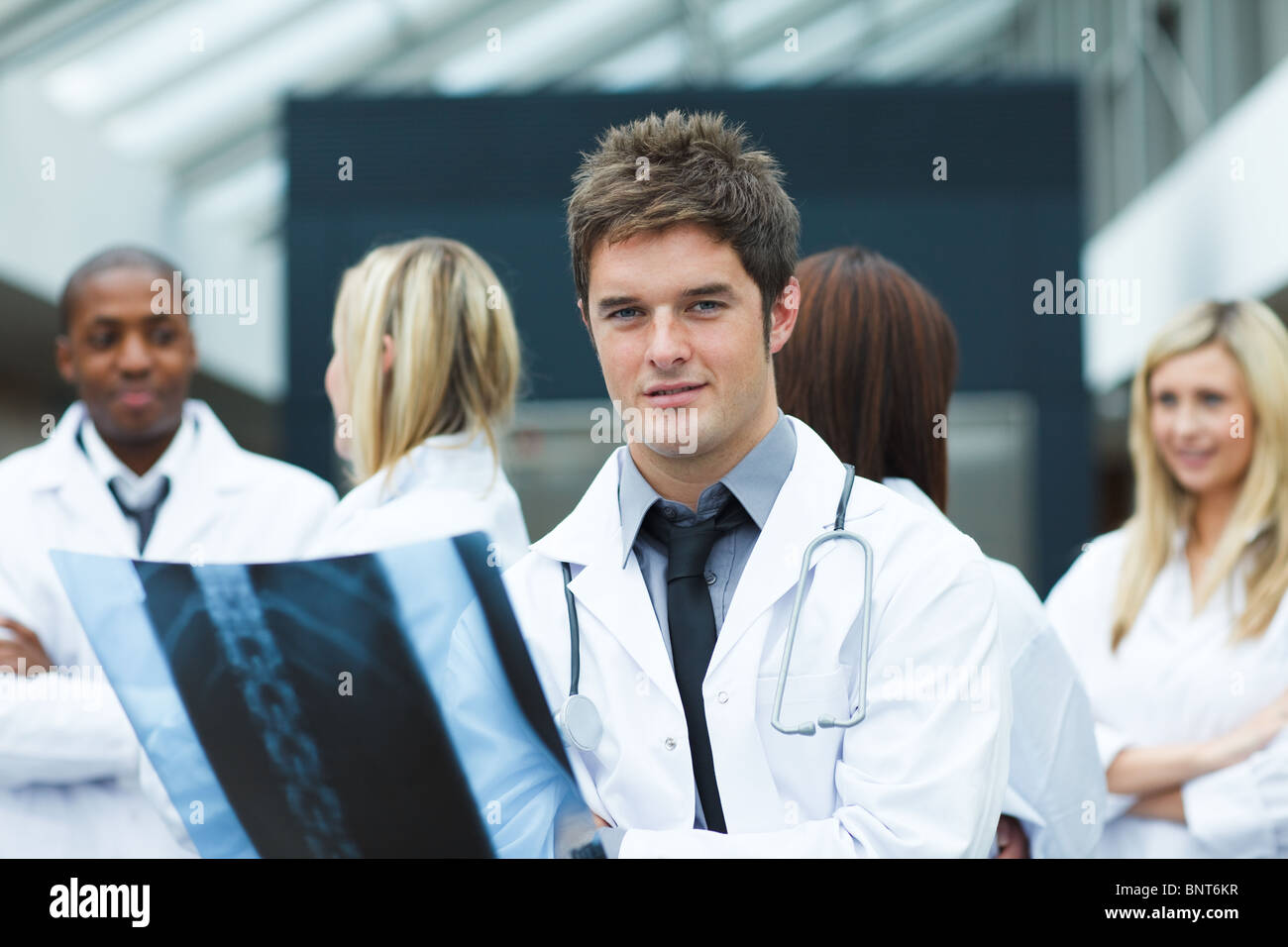 Giovane medico con un x-ray guardando la telecamera Foto Stock