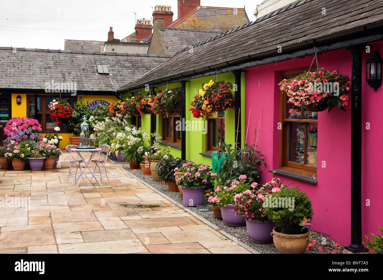 Cortile con dipinti colorati negozi, Beaumaris, Anglesey, Galles del Nord, Regno Unito Foto Stock